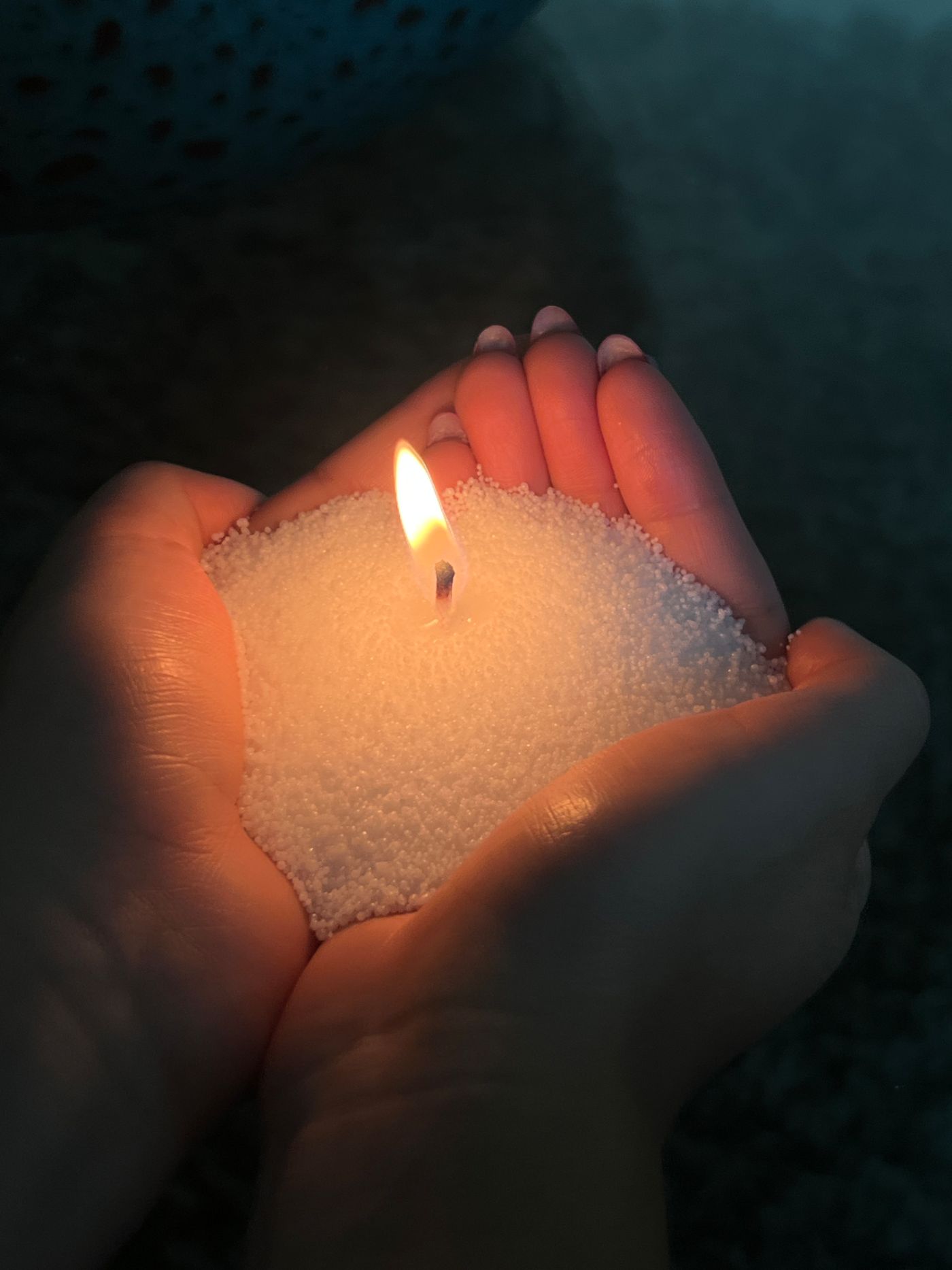 Mãos em concha perto da chama de uma vela em pó Flame Home